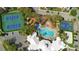 Aerial view showcasing a resort-style pool, tennis courts, basketball court, and community amenities surrounded by greenery at 2263 Wyndham Palms Way, Kissimmee, FL 34747