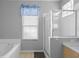 Bright bathroom features a glass-door shower, soaking tub, and a window for natural light at 2263 Wyndham Palms Way, Kissimmee, FL 34747