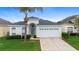 Attractive single-Gathering home featuring a well-kept lawn, palm tree, and an inviting front facade at 2263 Wyndham Palms Way, Kissimmee, FL 34747