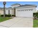 Charming home with a white garage door, manicured landscaping, and a well-maintained driveway at 2263 Wyndham Palms Way, Kissimmee, FL 34747