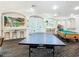 This game room features a ping pong table, a billiard table, arcade games, wall art and bar seating for fun and activities at 2263 Wyndham Palms Way, Kissimmee, FL 34747