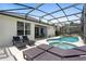 Spacious patio with a luxurious pool and spa combination in a screened enclosure at 2263 Wyndham Palms Way, Kissimmee, FL 34747