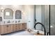 Modern bathroom featuring dual vanities, tub, and a glass-enclosed shower at 2612 Musselwhite Ave, Orlando, FL 32804