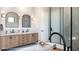 Luxury bathroom with dual vanities, a freestanding tub, and a glass-enclosed shower with herringbone tiling at 2612 Musselwhite Ave, Orlando, FL 32804