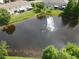 Aerial view of a pond with a fountain surrounded by well-manicured lawns and residential buildings at 2656 River Landing Dr, Sanford, FL 32771