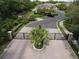 Elegant community entrance with stone pillars, iron gates, lush landscaping, and a paved roundabout at 2656 River Landing Dr, Sanford, FL 32771