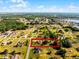 An aerial shot shows property lines in a verdant community with ponds, roads, and scattered trees under a sunny sky at 2726 La Alameda Ave, Kissimmee, FL 34746