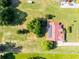 An aerial shot showcasing a house with solar panels on its red tiled roof, surrounded by lush greenery at 2726 La Alameda Ave, Kissimmee, FL 34746