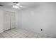 This bedroom features a ceiling fan, tile floors, and a closet with louvered doors at 2726 La Alameda Ave, Kissimmee, FL 34746