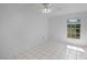 This bedroom has tile flooring, a ceiling fan, and a window with a view at 2726 La Alameda Ave, Kissimmee, FL 34746
