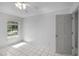 Bright bedroom with tile floors, a ceiling fan, a large window, and a door to another room at 2726 La Alameda Ave, Kissimmee, FL 34746