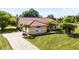 Charming single-story home with a well-manicured lawn, tiled roof, and a long driveway at 2726 La Alameda Ave, Kissimmee, FL 34746