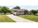Inviting single-story house featuring a terracotta roof, ample green lawn, and a spacious driveway at 2726 La Alameda Ave, Kissimmee, FL 34746