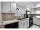 Traditional kitchen featuring white cabinets, tile backsplash, and stainless steel sink at 2726 La Alameda Ave, Kissimmee, FL 34746