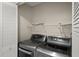 This laundry room includes a washer, dryer, white storage shelves and closet at 2726 La Alameda Ave, Kissimmee, FL 34746