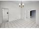 A shot of a vacant living room with arched entryways, tile floors and light fixture at 2726 La Alameda Ave, Kissimmee, FL 34746