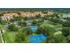 Community aerial view featuring a playground, tennis court, basketball court, and lush green common areas at 2785 Almaton Loop # 202, Kissimmee, FL 34747