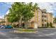 Well-maintained exterior view showcasing a tan building with manicured landscaping and parking at 2785 Almaton Loop # 202, Kissimmee, FL 34747