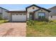 Charming single-story home featuring a brick driveway, a two-car garage, and well-maintained landscaping at 3128 Oxbow Ct, Harmony, FL 34773