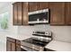 Modern kitchen featuring stainless steel appliances, wooden cabinetry, and a white subway tile backsplash at 3128 Oxbow Ct, Harmony, FL 34773