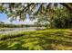 Backyard with a large grassy area leading to the lake and private wooden dock at 3359 Scarlet Dr, Sanford, FL 32773