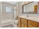 Well-lit bathroom features a tub/shower combination, vanity with natural wood accents, and neutral color palette at 3359 Scarlet Dr, Sanford, FL 32773