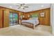 Bedroom with wood paneling, views to waterfall, and sliding glass doors to exterior at 3359 Scarlet Dr, Sanford, FL 32773