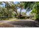 Home exterior featuring mature trees, covered parking, and a large yard at 3359 Scarlet Dr, Sanford, FL 32773