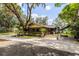 View of the side and back of the home featuring mature trees, a large yard, and covered parking at 3359 Scarlet Dr, Sanford, FL 32773