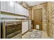 Well-organized laundry room features modern washer and dryer, white cabinets and rustic wood walls at 3359 Scarlet Dr, Sanford, FL 32773