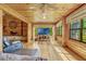 Cozy living room featuring wood-paneled walls, hardwood floors and large windows offering natural light at 3359 Scarlet Dr, Sanford, FL 32773