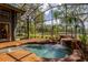 Relaxing spa pool featuring a rock waterfall and surrounding tropical plants in a screened-in enclosure at 3359 Scarlet Dr, Sanford, FL 32773