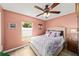 Comfortable bedroom features a ceiling fan and a window providing natural light at 4051 Eagle Feather Dr, Orlando, FL 32829