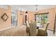 Cozy dining area with wood-look tile floors, modern lighting, glass table, and views to the kitchen at 4051 Eagle Feather Dr, Orlando, FL 32829