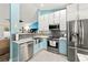 Modern kitchen with stainless steel appliances, stylish cabinets, sleek countertops, and views to the living room at 4051 Eagle Feather Dr, Orlando, FL 32829