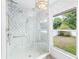 Modern bathroom with a tiled glass shower enclosure and natural light from the window at 4051 Eagle Feather Dr, Orlando, FL 32829