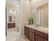 Well-designed bathroom with adjacent rooms, offering an efficient space, featuring ample counter space and dark wood cabinets at 5062 Otters Den Trl, Sanford, FL 32771