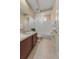 Bathroom with tan flooring features a vanity with a sink, toilet, and tiled shower with curtain at 5062 Otters Den Trl, Sanford, FL 32771