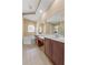Bright bathroom featuring double sinks, a large mirror, and a soaking tub for a luxurious and functional space at 5062 Otters Den Trl, Sanford, FL 32771