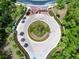 Beautiful community entrance featuring a circular roundabout with lush landscaping, a central palm tree, and an ornate gated entrance at 5062 Otters Den Trl, Sanford, FL 32771