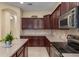 A close up of the kitchen with dark wood cabinets, stone countertops and stainless steel appliances at 5062 Otters Den Trl, Sanford, FL 32771