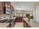 A kitchen with stainless steel appliances, a tile backsplash, and dark wood cabinets at 5062 Otters Den Trl, Sanford, FL 32771