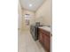 Functional laundry room with washer, dryer, utility sink, and storage shelves at 5062 Otters Den Trl, Sanford, FL 32771