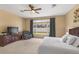 Sunny main bedroom featuring a backyard view, ceiling fan, dresser, and cozy armchair at 5062 Otters Den Trl, Sanford, FL 32771