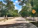Scenic street with white fencing, lush greenery, and wildlife crossing sign for safety at 5062 Otters Den Trl, Sanford, FL 32771