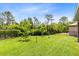 Backyard with lush green grass and mature landscaping at 613 Crownclover Ave, Orlando, FL 32828