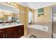 Bright bathroom with a soaking tub, a glass shower, and dark wood cabinets at 613 Crownclover Ave, Orlando, FL 32828