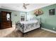 Bedroom with green walls, ceiling fan, metal-framed bed, and dresser at 613 Crownclover Ave, Orlando, FL 32828