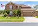 Charming two-story home with a well-manicured lawn, beautiful landscaping, and a spacious two-car garage at 613 Crownclover Ave, Orlando, FL 32828