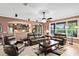 Open living room boasts tile floors, an arched doorway to the kitchen, and comfortable leather furniture at 613 Crownclover Ave, Orlando, FL 32828